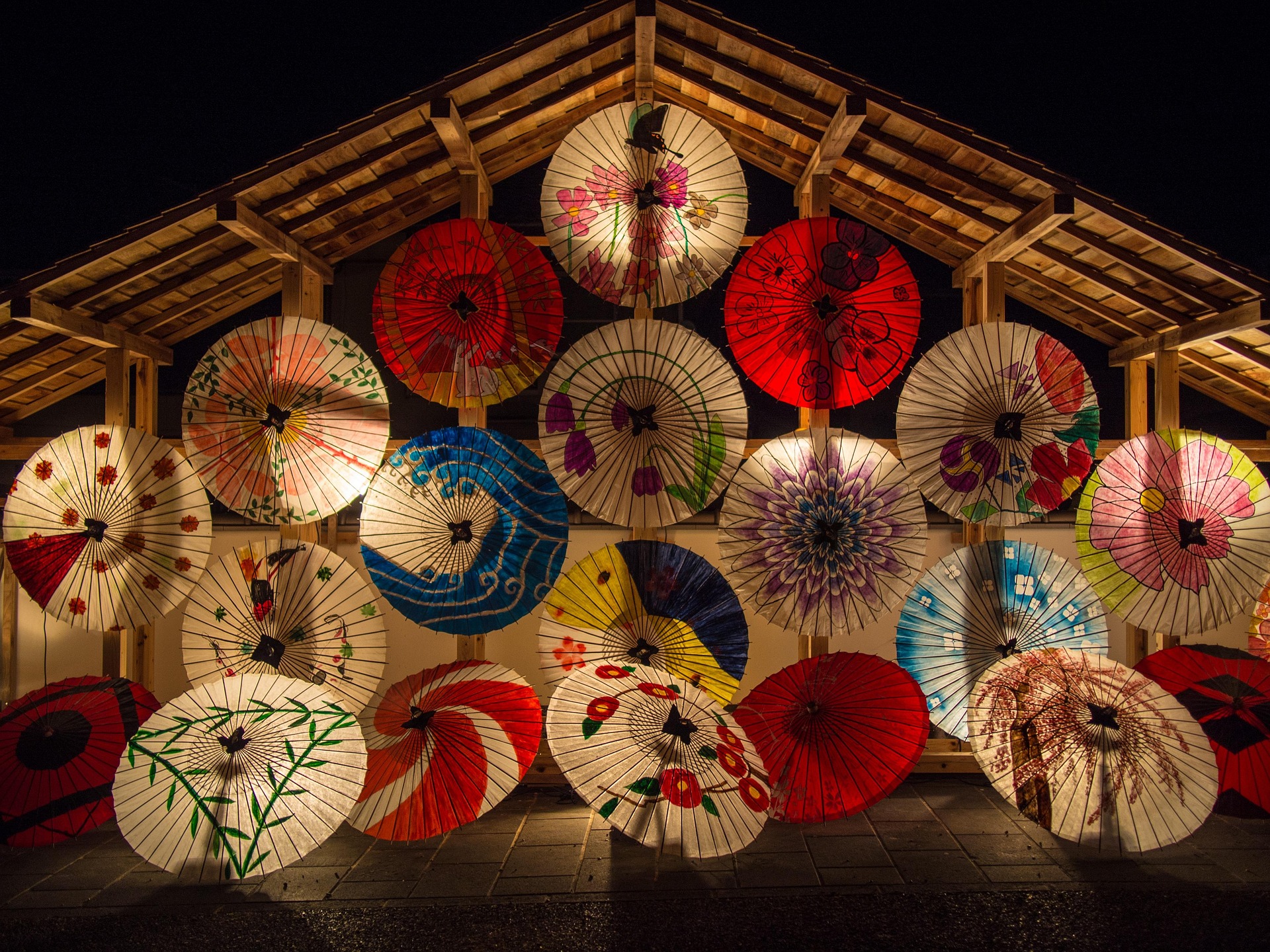 Glowing painted Japanese paper umbrellas at night