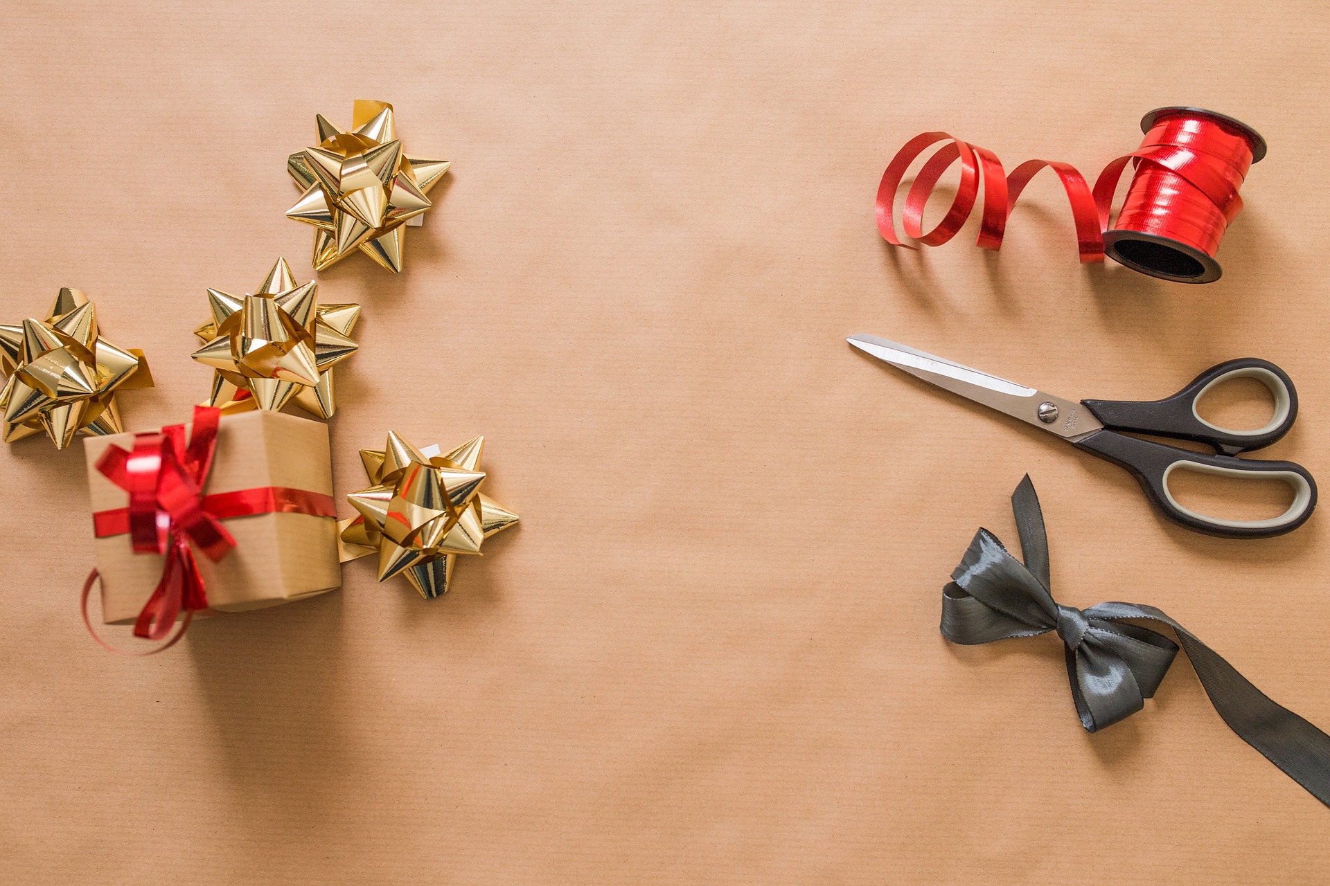 Gift wrapping with kraft paper, gold stars and red ribbon