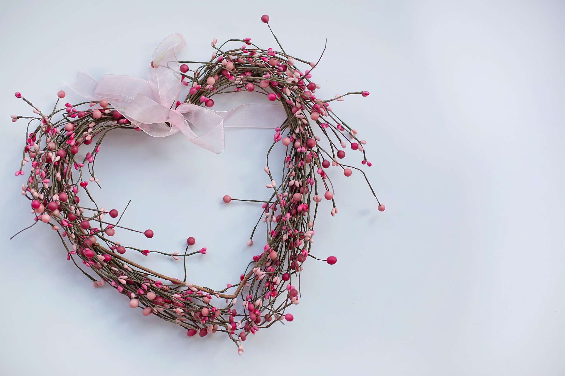 Heart-shaped twig wreath with pink berries and a sheer bow